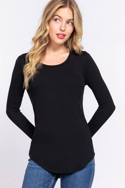 Woman wearing a black long-sleeve top and blue jeans on a white background