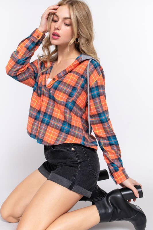 Woman wearing a plaid shirt and black shorts on a white background